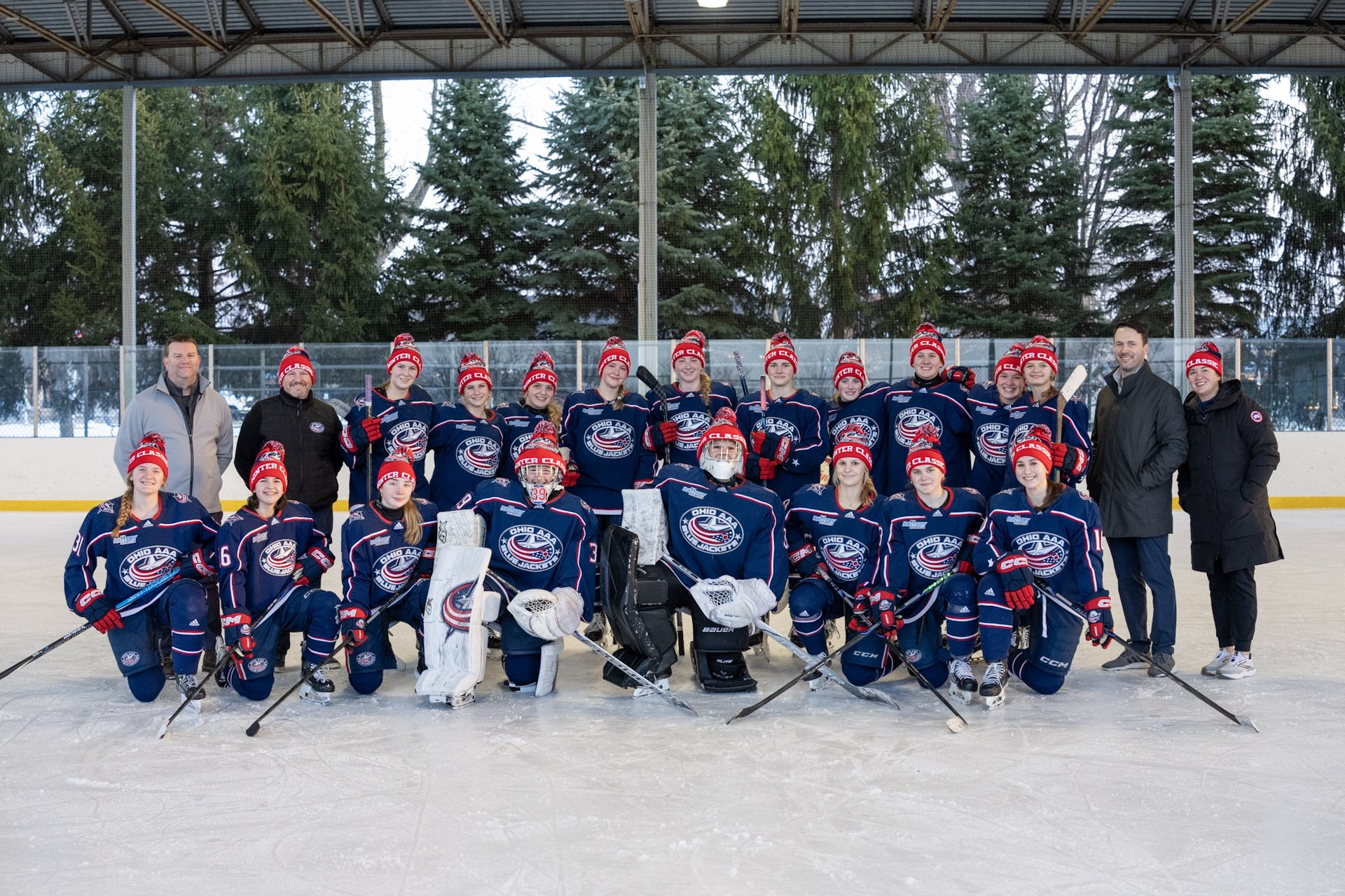 Girls' hockey team in custom red, white, and navy jerseys