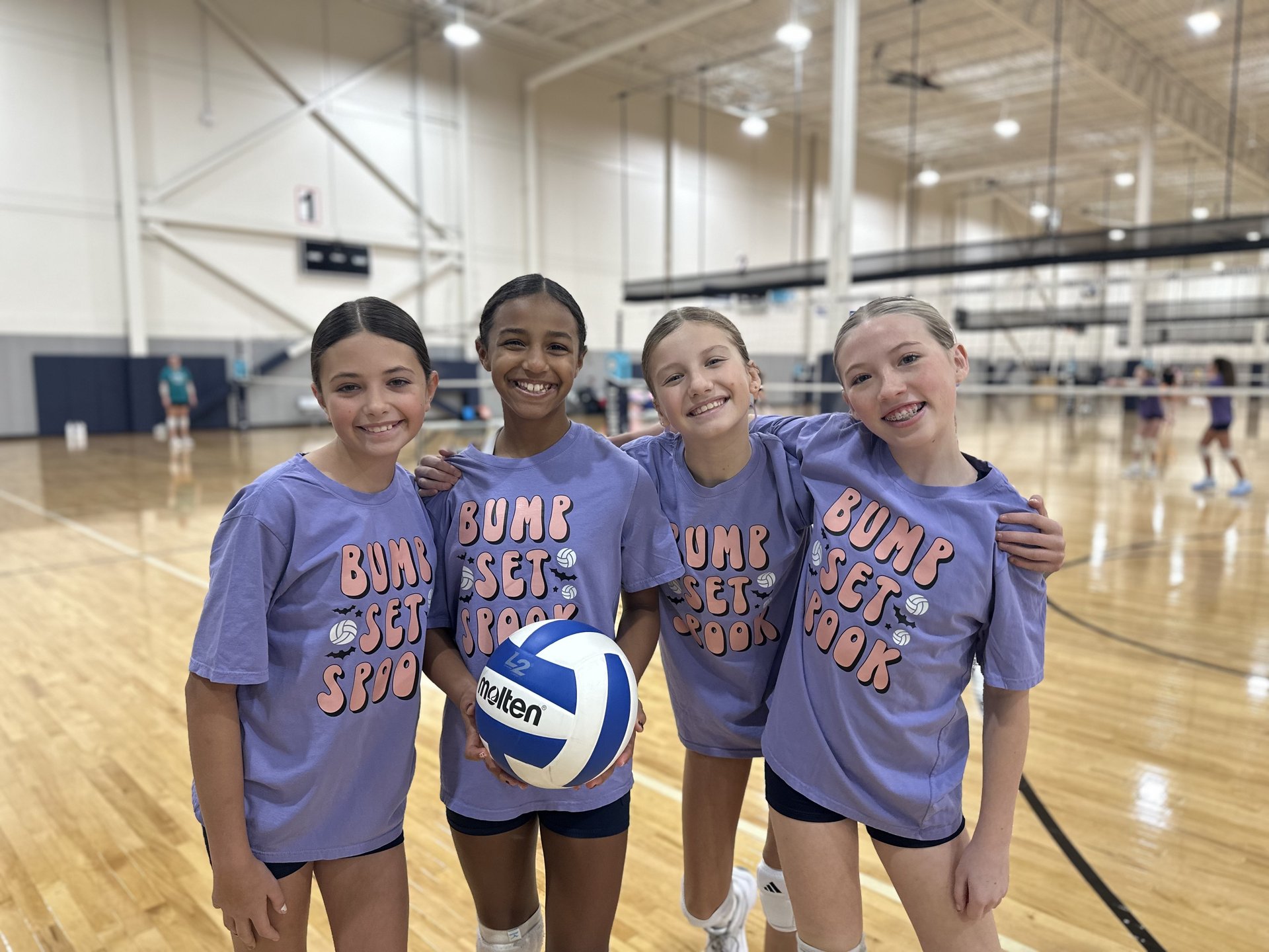 Four girls in matching lavender volleyball spirit shirts